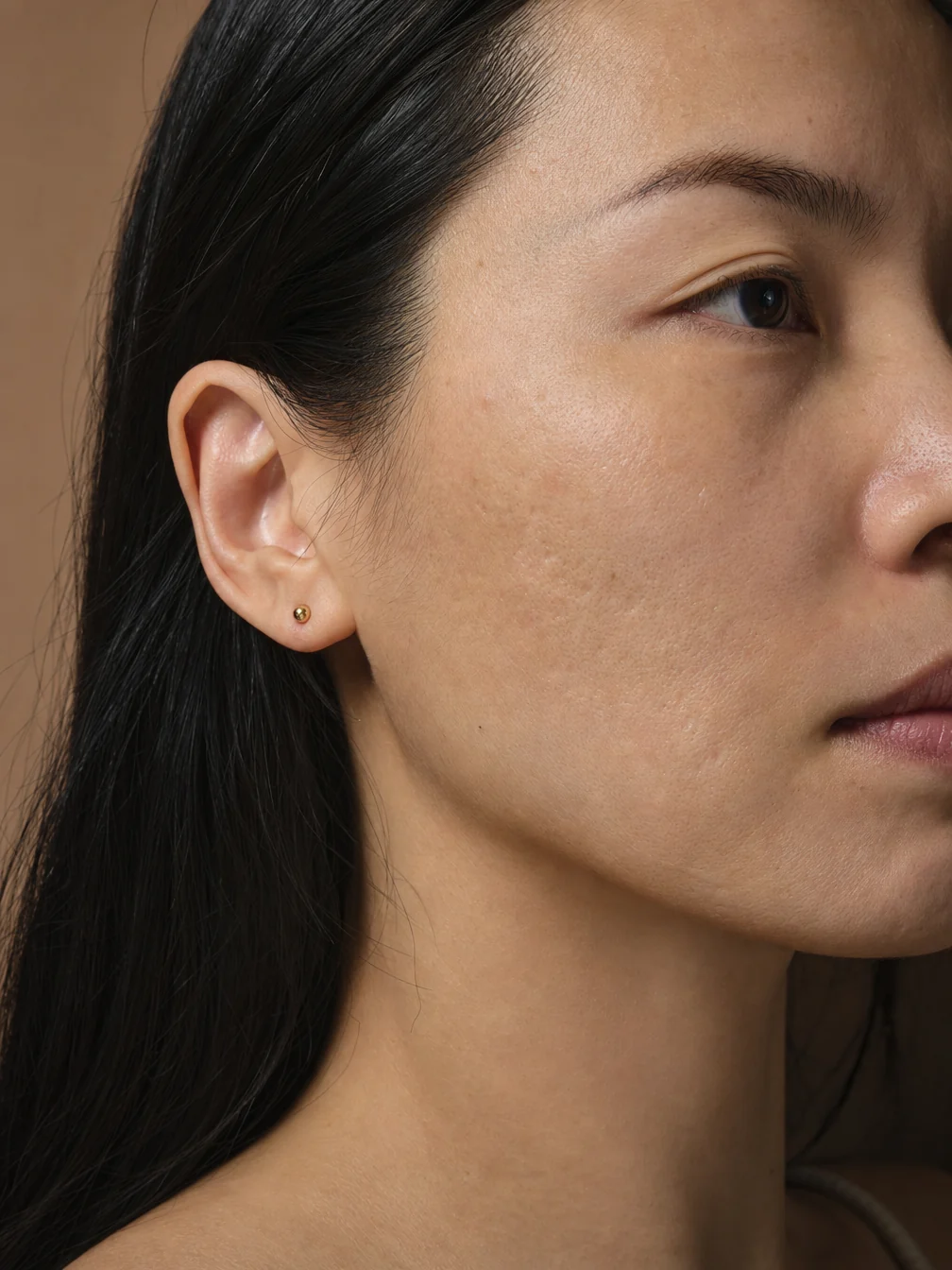 Profile of a woman with black hair, the cheek and skin texture in close-up