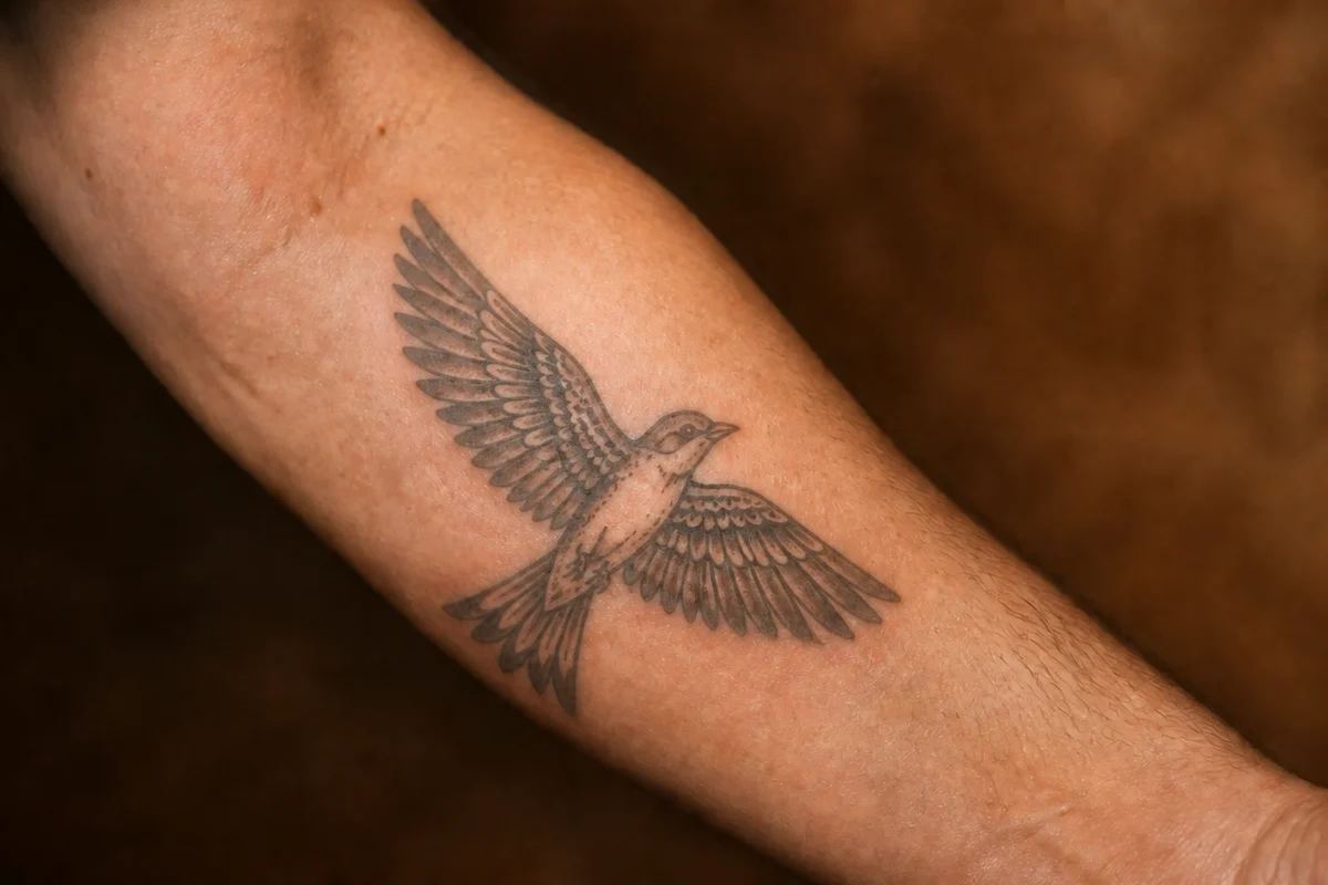 The same tattoo turned grey, outlines softened, but still perfectly legible